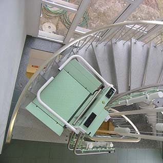 Ein Rollstuhl-Treppenlift auf einer Treppe mit Kurven innen