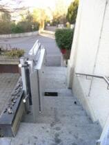 Ein Plattformlift im Aussenbereich über eine längere Zugangstreppe