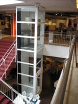 Ein Lift in einem selbsttragenden Glasschacht in einem Einkaufszentrum