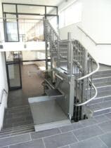 Der Plattformlift einseitig offen auf der zweiten Zwischenetage (Schulhaus)
