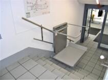 Der Rollstuhllift während der Fahrt über die kurze gerade Eingangstreppe